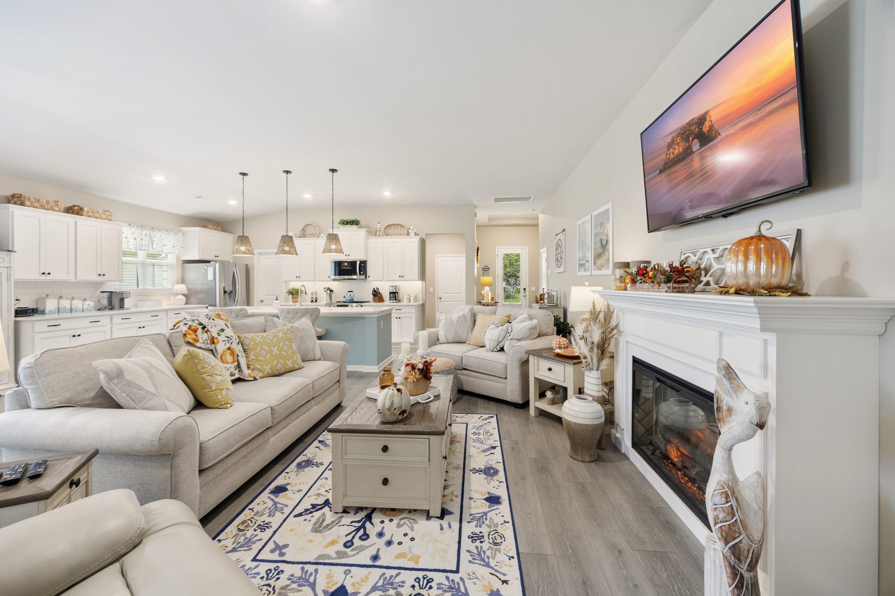 Open great room with fireplace and kitchen beyond